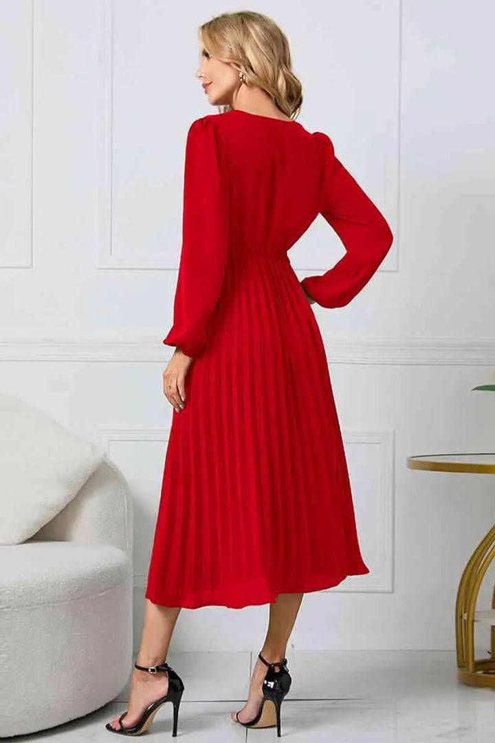 Helkroppsbild av en modell som bär den eleganta veckade klänningen med flytande fall.