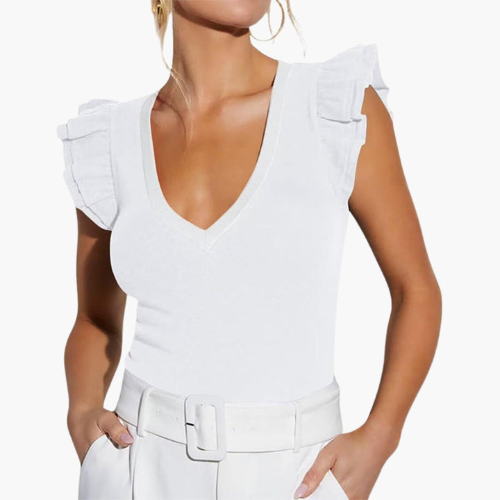 Elegant vit ärmlös topp med V-ringning och volangaxlar. Perfekt damtopp för sommar och festliga tillfällen.