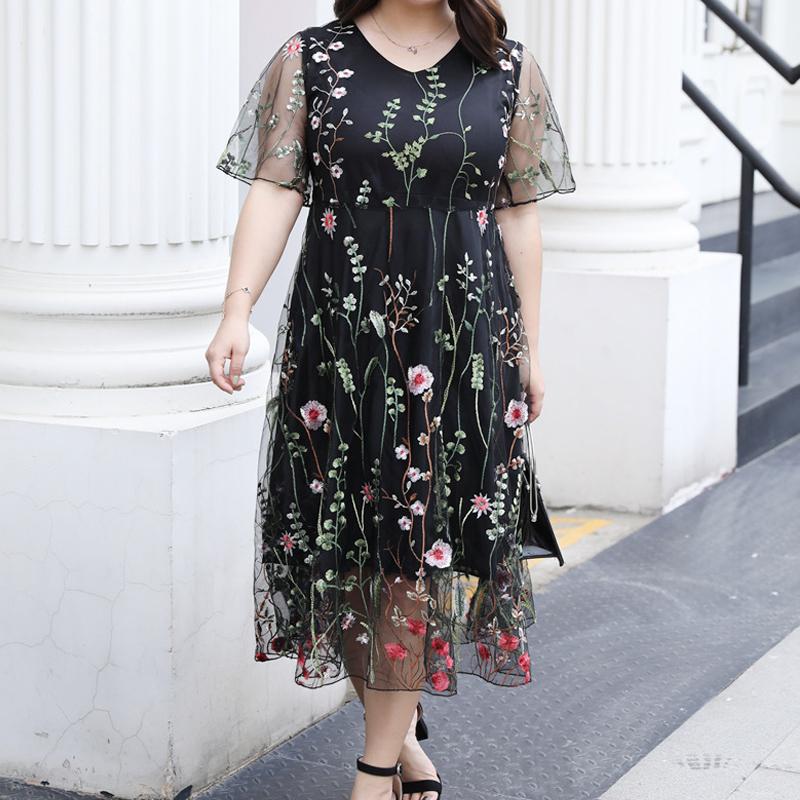 "Eleganta blommig plus size klänning, broderad med transparenta ärmar, framhäver kurvor och ger en sofistikerad look."