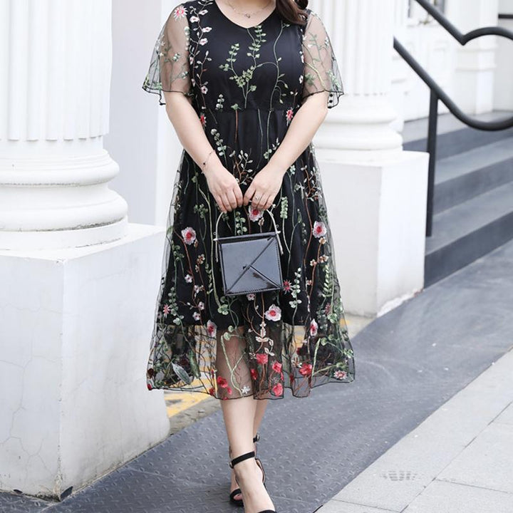 "Eleganta blommig plus size klänning, broderad med transparenta ärmar, framhäver kurvor och ger en sofistikerad look."