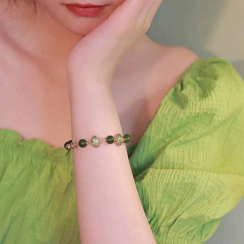 "Eleganta damarmband i guld med kalcedon och fyrklöver, fångar positiv energi och skönhet, perfekt accessoar."