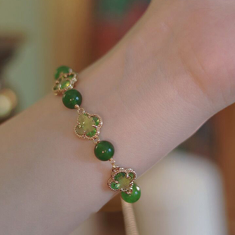 "Eleganta damarmband i guld med kalcedon och fyrklöver, fångar positiv energi och skönhet, perfekt accessoar."