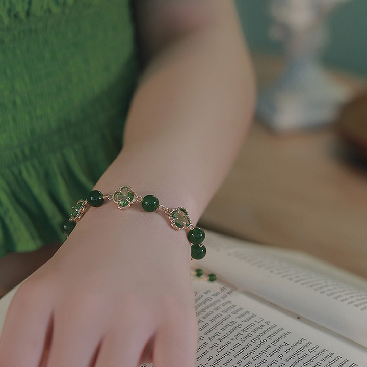 "Eleganta damarmband i guld med kalcedon och fyrklöver, fångar positiv energi och skönhet, perfekt accessoar."