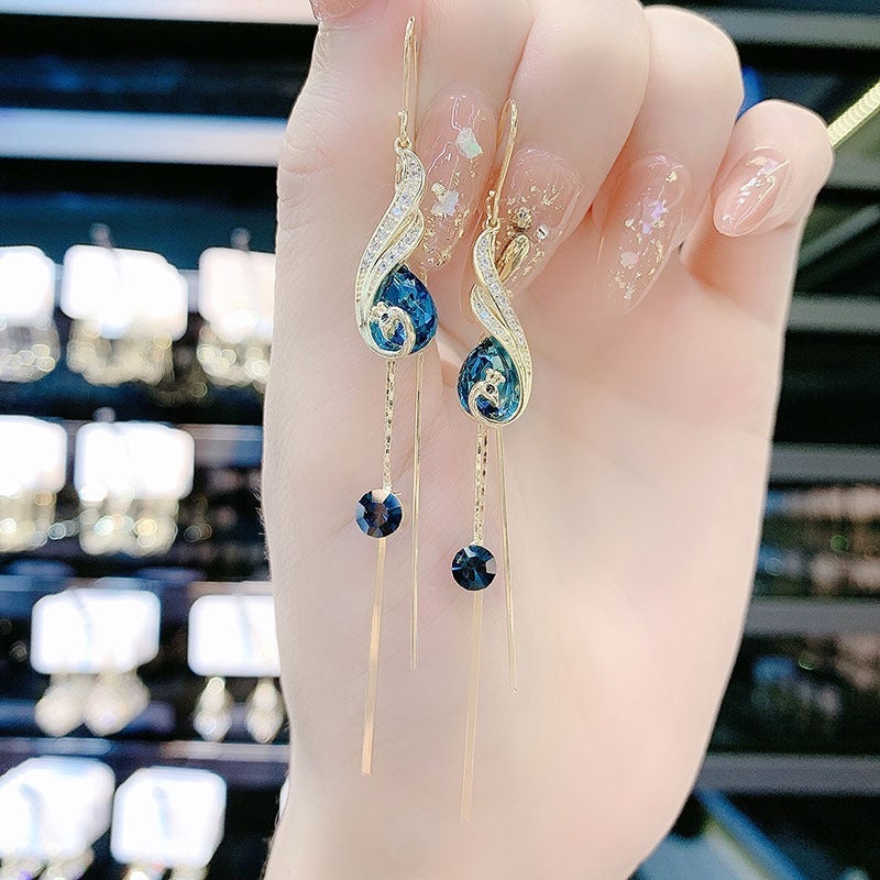 "Eleganta påfågelörhängen för damer i blått och rött med strass och pärlor, utformade för stil och elegans."
