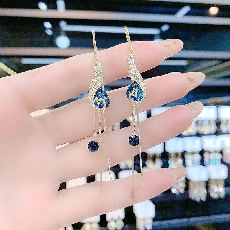 "Eleganta påfågelörhängen för damer i blått och rött med strass och pärlor, utformade för stil och elegans."
