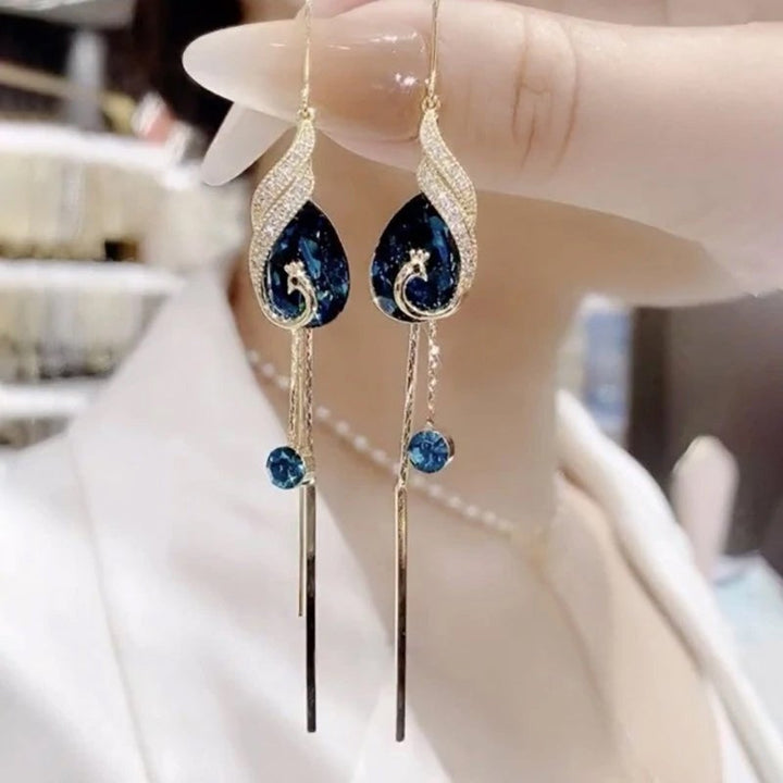 "Eleganta påfågelörhängen för damer i blått och rött med strass och pärlor, utformade för stil och elegans."