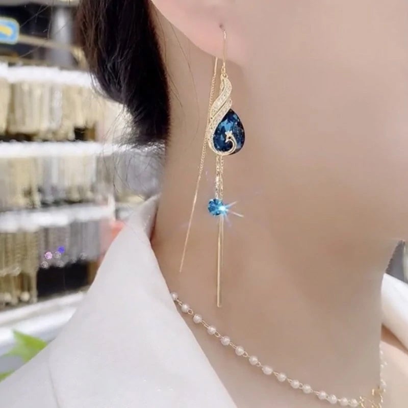 "Eleganta påfågelörhängen för damer i blått och rött med strass och pärlor, utformade för stil och elegans."