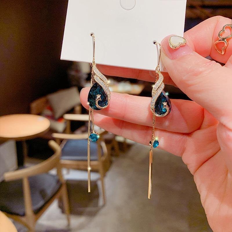 "Eleganta påfågelörhängen för damer i blått och rött med strass och pärlor, utformade för stil och elegans."
