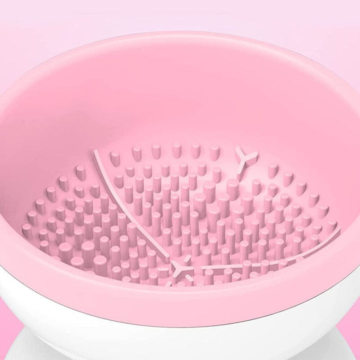"Elektrisk makeupborstrengörare i rosa, kompakt med rund design, perfekt för effektiv borstvård på resor."