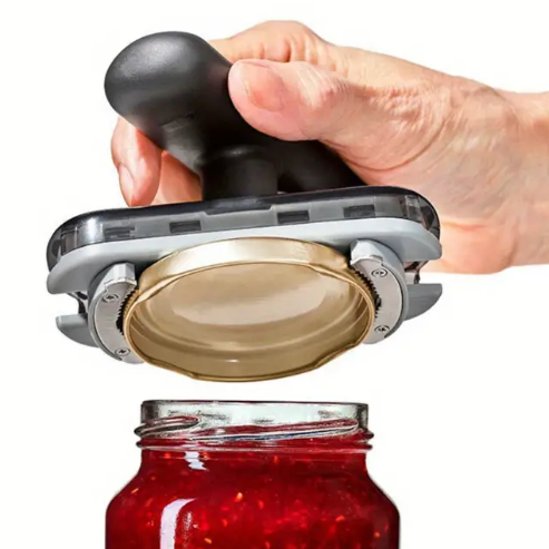 Användare öppnar en burk enkelt med den ergonomiska burköppnaren. Ett oumbärligt köksredskap för matlagning.