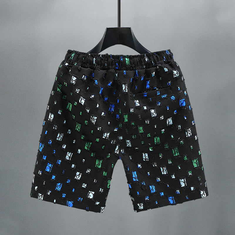 Detaljbild av slitna, färgglada herrjeansshorts i denim med bekväm elastisk midja.