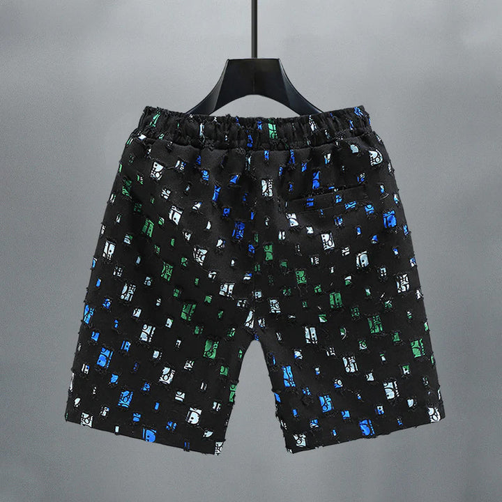 Detaljbild av slitna, färgglada herrjeansshorts i denim med bekväm elastisk midja.
