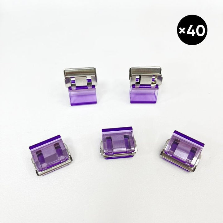 "Färgglada metallpappersklämmor i grönt, gult, lila, rosa, transparent och blått, perfekt för kontor och skola."