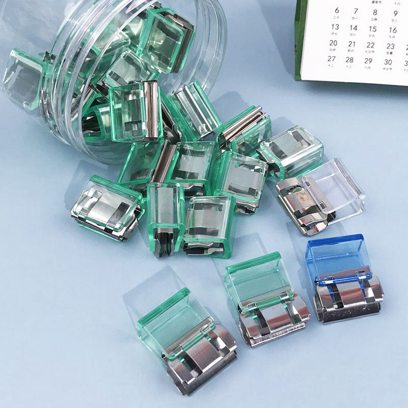 "Färgglada metallpappersklämmor i grönt, gult, lila, rosa, transparent och blått, perfekt för kontor och skola."