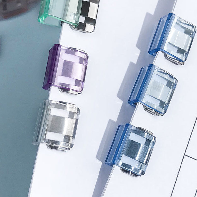 "Färgglada metallpappersklämmor i grönt, gult, lila, rosa, transparent och blått, perfekt för kontor och skola."