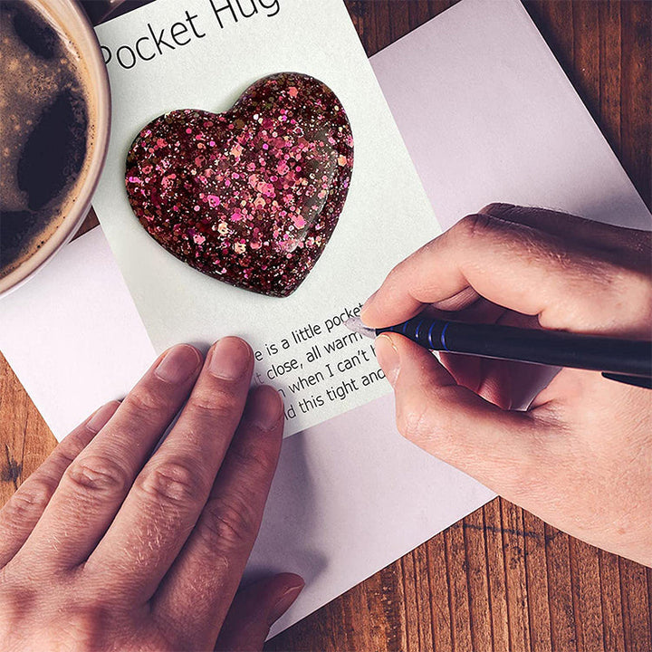 "Färgglatt hjärta i harts, fickvänlig accessoar med kärleksfullt budskap i olika nyanser: guld, blå, lila, grön."