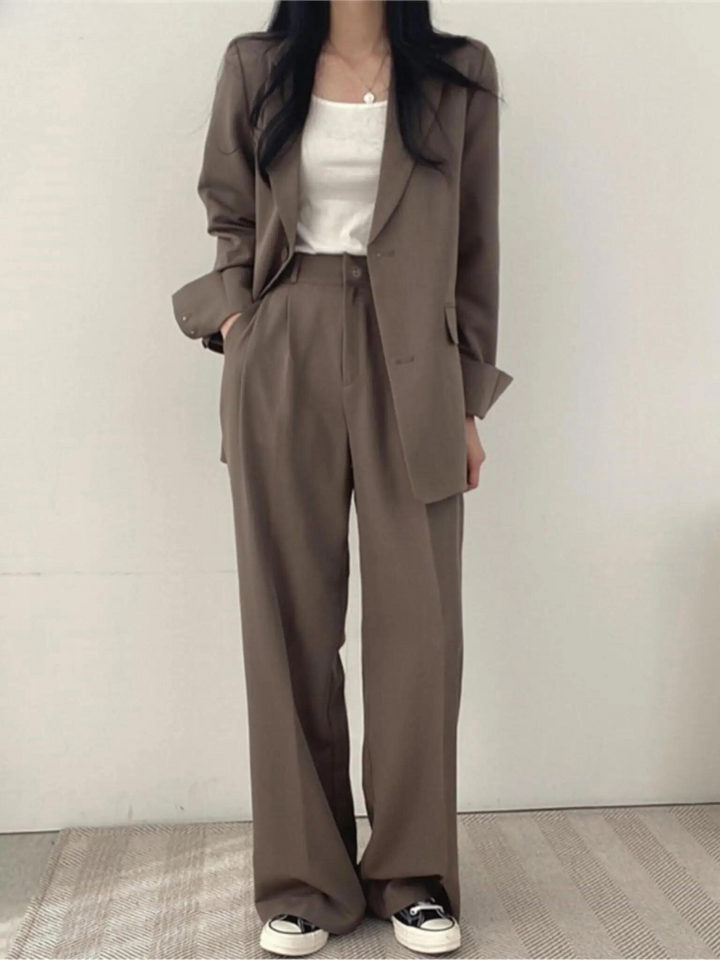 Svart figursydd byxkostym för kvinnor, med en stilren blazer och vida byxor, en klassiker för arbetskläder.