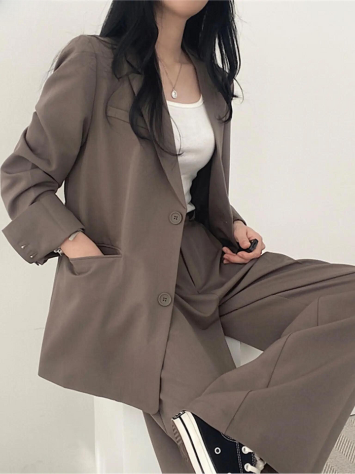 Modern khaki tvådelad kostym, figursydd blazer och vida byxor med hög midja, perfekt för elegant mode.