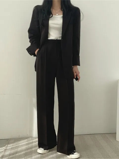 Elegant kontorskläder: Damkostym med figursydd blazer och vida byxor i en sofistikerad design.
