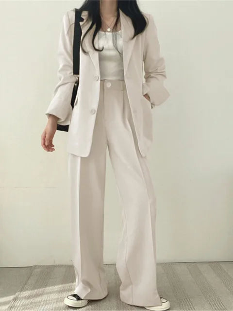Komplett damkostymset: Figursydd blazer och vida byxor. Elegant mode och bekväma arbetskläder.