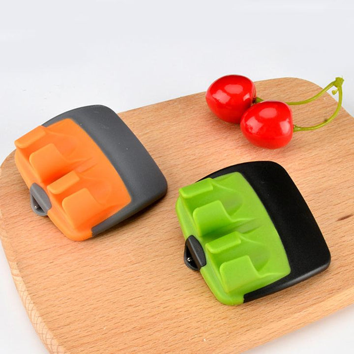 "Fingerskalare i grön och orange, ergonomisk design, kökspryl för säker och enkel hantering av frukt och grönsaker."