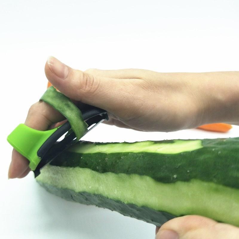 "Fingerskalare i grön och orange, ergonomisk design, kökspryl för säker och enkel hantering av frukt och grönsaker."