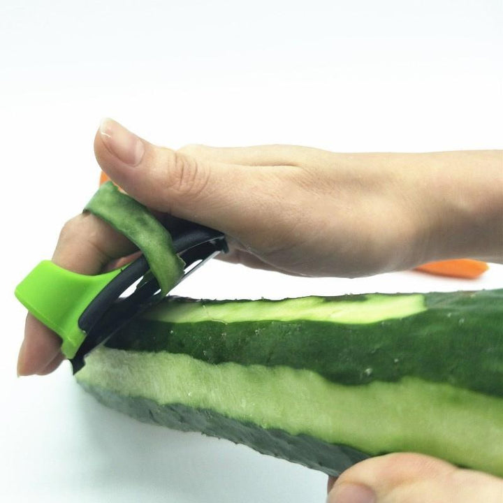 "Fingerskalare i grön och orange, ergonomisk design, kökspryl för säker och enkel hantering av frukt och grönsaker."