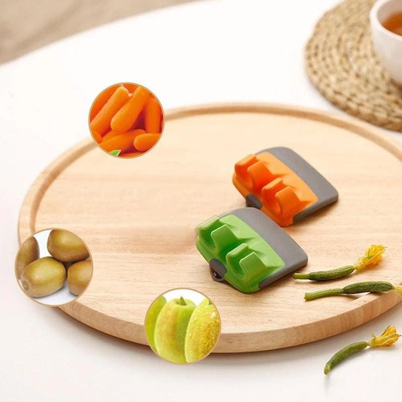 "Fingerskalare i grön och orange, ergonomisk design, kökspryl för säker och enkel hantering av frukt och grönsaker."