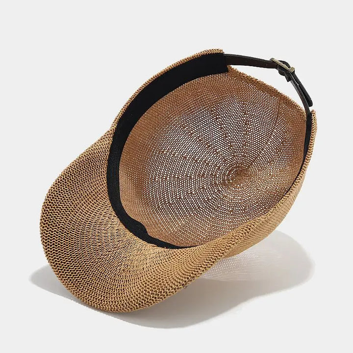 Detaljbild av flätad solhatt i naturmaterial med bred skärm, designad för UV-skydd. En modern sommarhatt.
