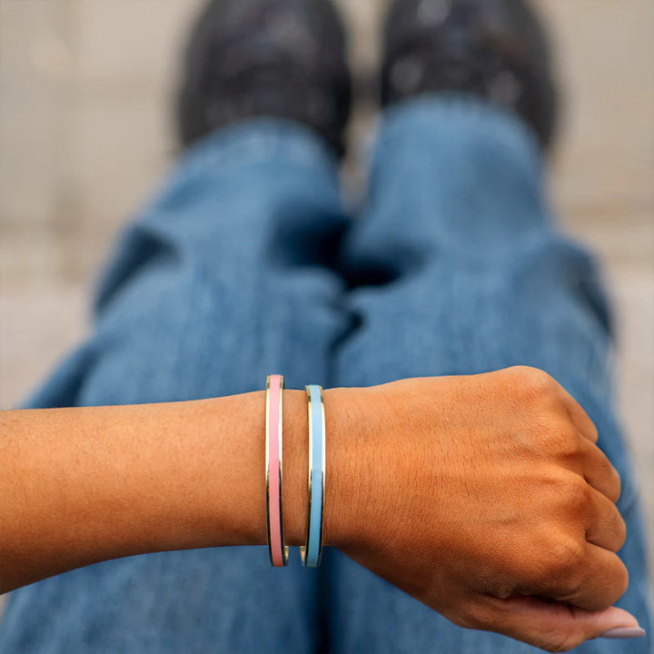 "Flerfärgat damarmband i robust stål med justerbar passform och livfulla orange, gula, blå, rosa, röda och svarta färger."