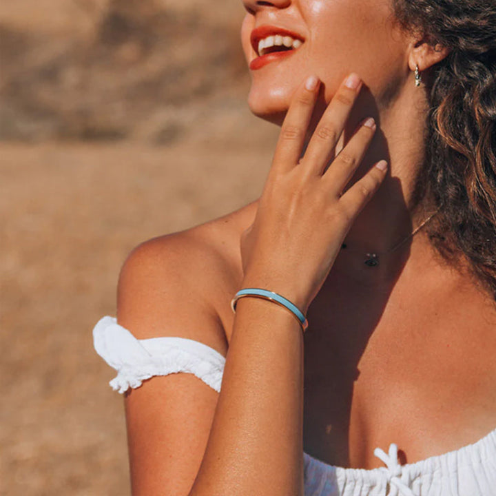 "Flerfärgat damarmband i robust stål med justerbar passform och livfulla orange, gula, blå, rosa, röda och svarta färger."