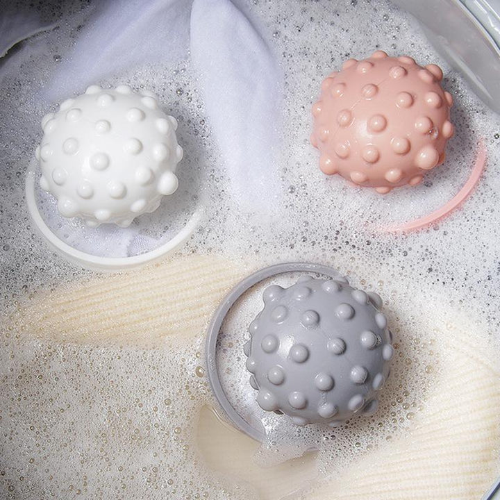 "Flytande husdjurshårfångare, blå färg, flyter ovanför kläderna i tvättmaskin för att samla djurhår effektivt."