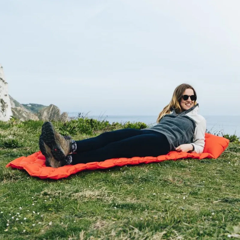 "Fuktsäker uppblåsbar campingmadrass med kudde, hållbart material, blå färg, robust och kompakt design för utomhusbruk."