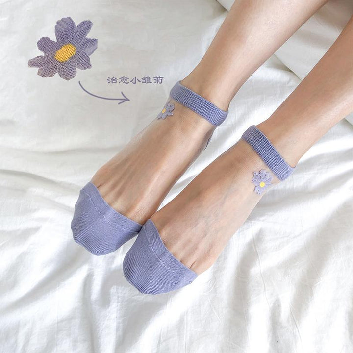 "Genomskinliga damsockor med blommotiv, feminin design med spets- och blomdetaljer, perfekt för sommaroutfits."