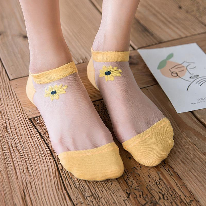 "Genomskinliga damsockor med blommotiv, feminin design med spets- och blomdetaljer, perfekt för sommaroutfits."