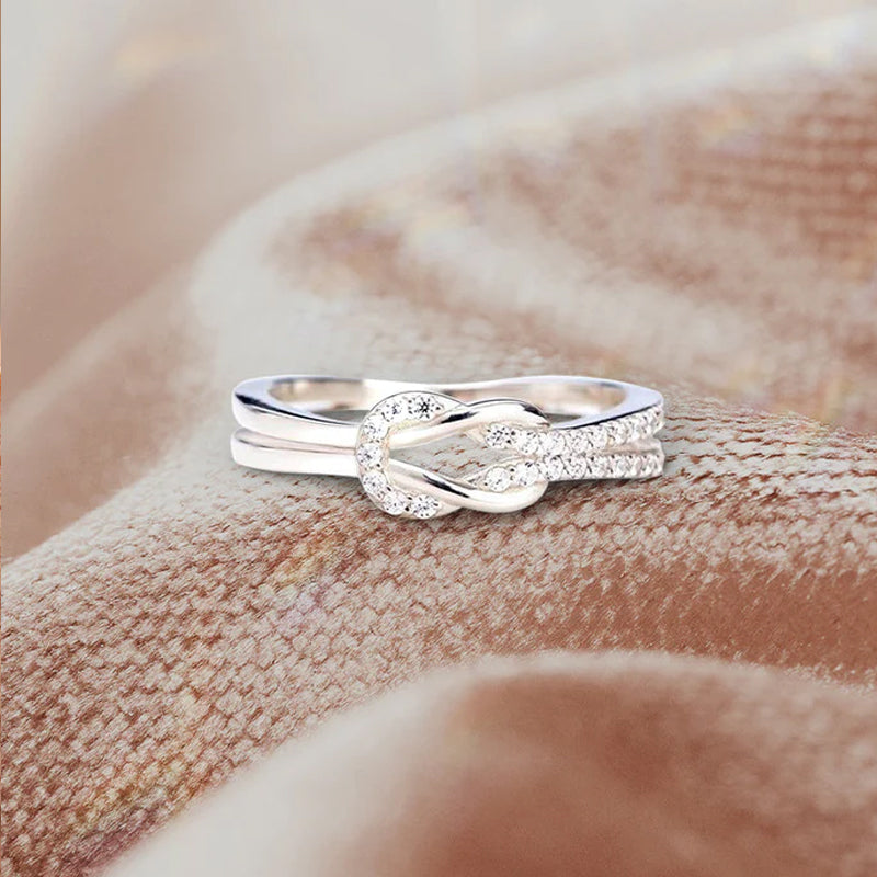 "Glänsande länkad ring i silver och roseguld, symbol för evigt band. Elegant, tidlös design, perfekt accessoar."