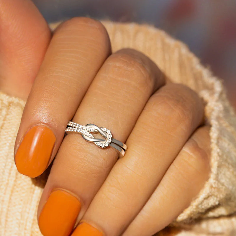 "Glänsande länkad ring i silver och roseguld, symbol för evigt band. Elegant, tidlös design, perfekt accessoar."