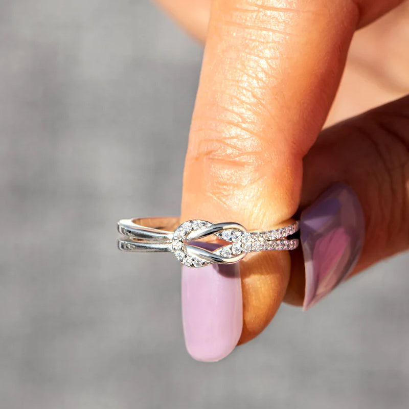 "Glänsande länkad ring i silver och roseguld, symbol för evigt band. Elegant, tidlös design, perfekt accessoar."