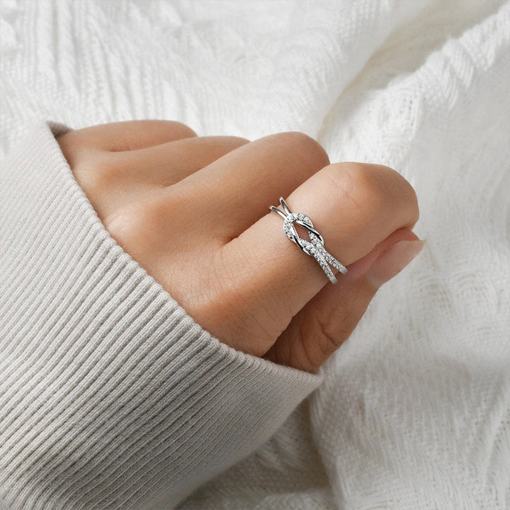 "Glänsande länkad ring i silver och roseguld, symbol för evigt band. Elegant, tidlös design, perfekt accessoar."