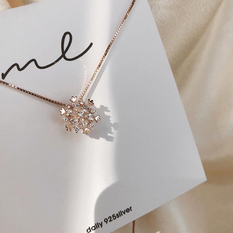 "Glänsande snöflinga halsband för damer i zirkon, justerbar längd, roséguld och silver, elegant och tidlös design."