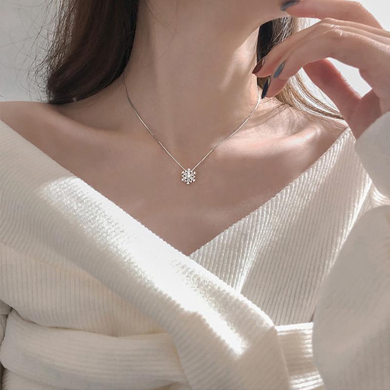 "Glänsande snöflinga halsband för damer i zirkon, justerbar längd, roséguld och silver, elegant och tidlös design."