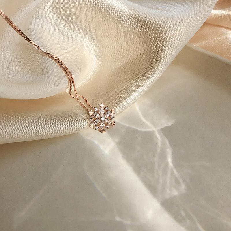 "Glänsande snöflinga halsband för damer i zirkon, justerbar längd, roséguld och silver, elegant och tidlös design."