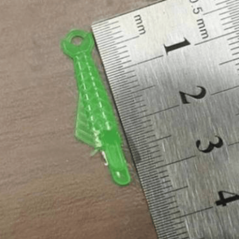Grön fiskformad nålträdare av plast för symaskiner, enkel trädning, slitstark och kompatibel med äldre och nya maskiner.