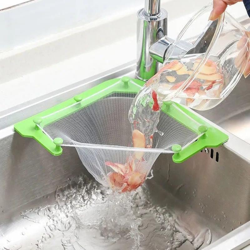 "Grönt triangulärt diskbänkfilter med elastiska nätpåsar, perfekt för kökshörn, effektiv avfallshantering."