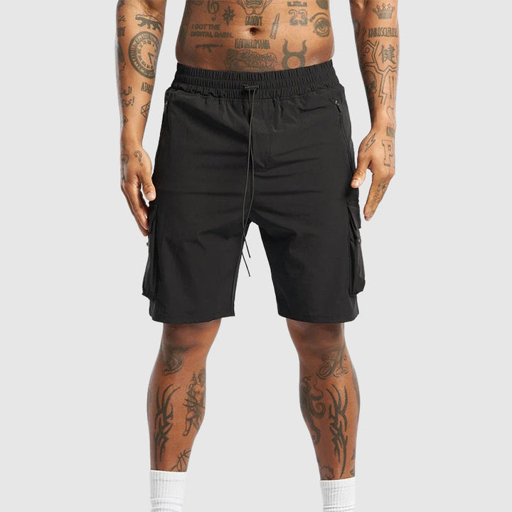 Detaljbild av herrshorts i gul färg, visar snabbtorkande material och praktiska sidofickor.