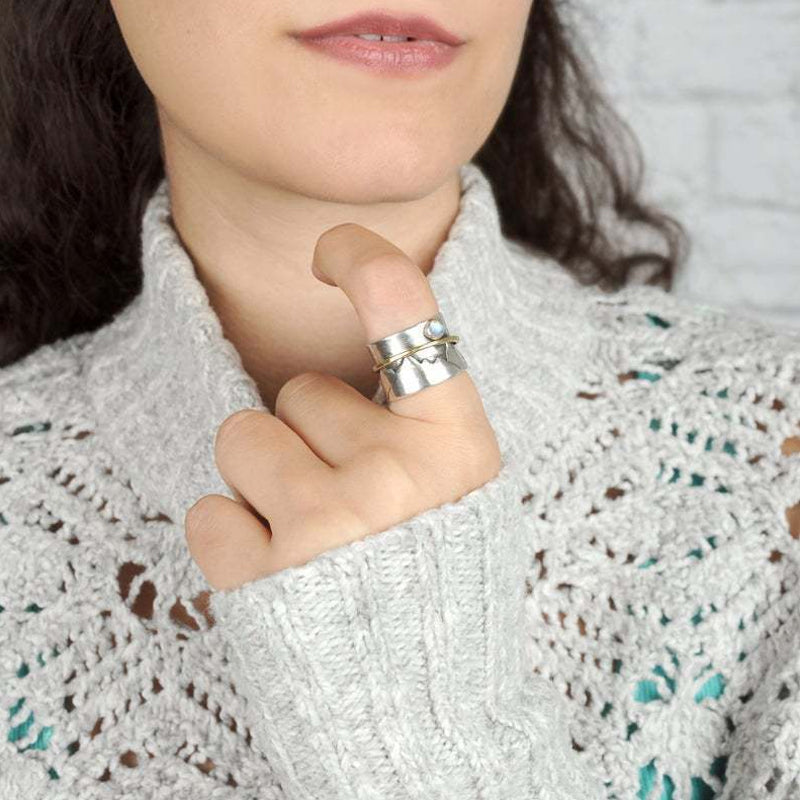 "Guldfärgad damhjärtring med måne och berg, elegant accessoar med naturtema"