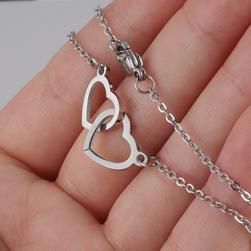 "Halsband för kvinnor med två sammanflätade hjärtan i titan stål, elegant romantisk design i guld, roséguld eller silver."