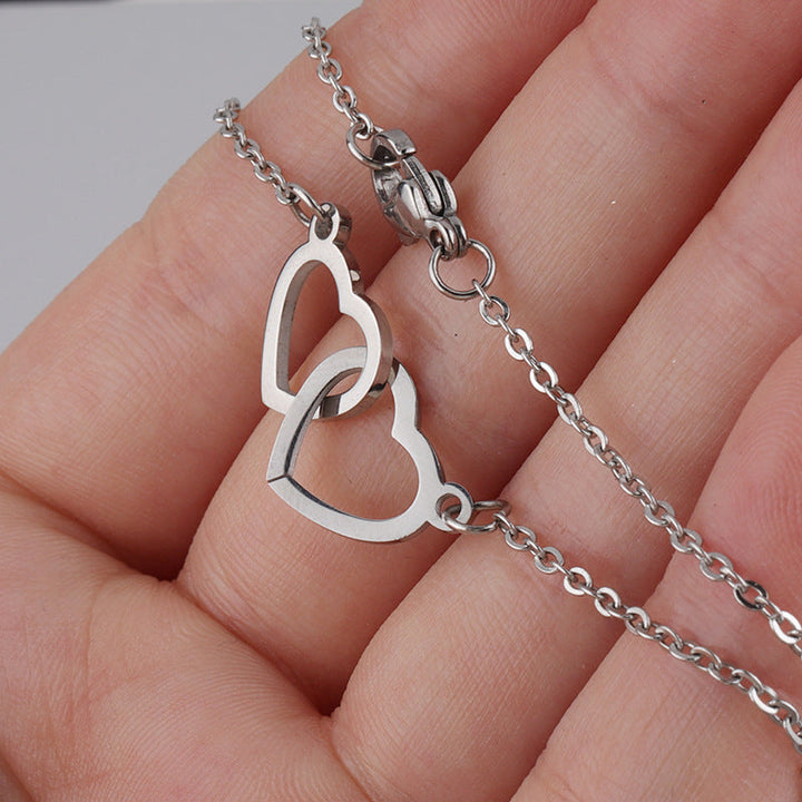 "Halsband för kvinnor med två sammanflätade hjärtan i titan stål, elegant romantisk design i guld, roséguld eller silver."