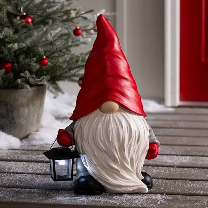 "Handgjord snögubbe juldekoration med LED-lykta, snöhatt, röd halsduk i trädgård, för magisk julstämning i hemmet."