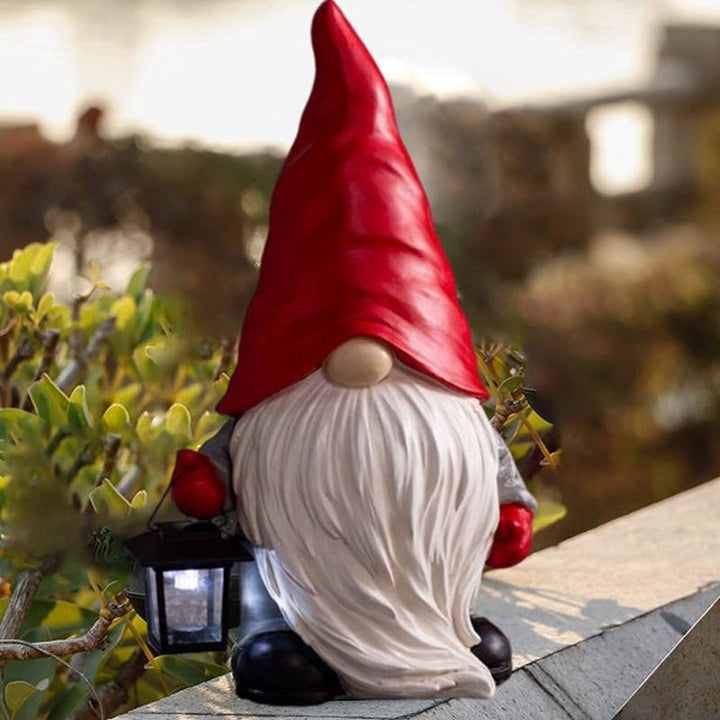 "Handgjord snögubbe juldekoration med LED-lykta, snöhatt, röd halsduk i trädgård, för magisk julstämning i hemmet."